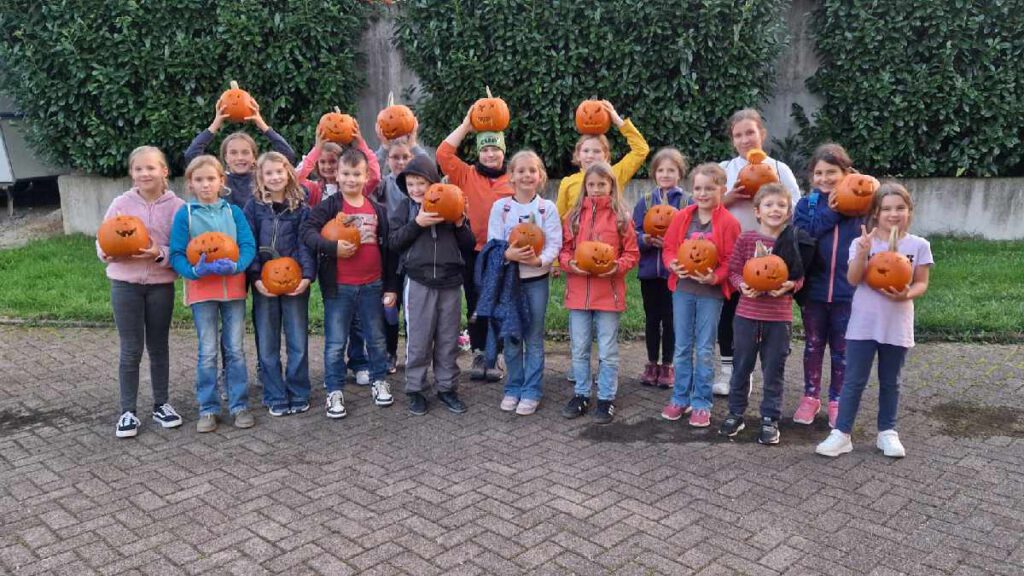 Das Foto zeigt die Kinder aus der jüngeren Steinacher JRK Gruppe, wie sie ihre gebastelten Kürbis präsentieren.
